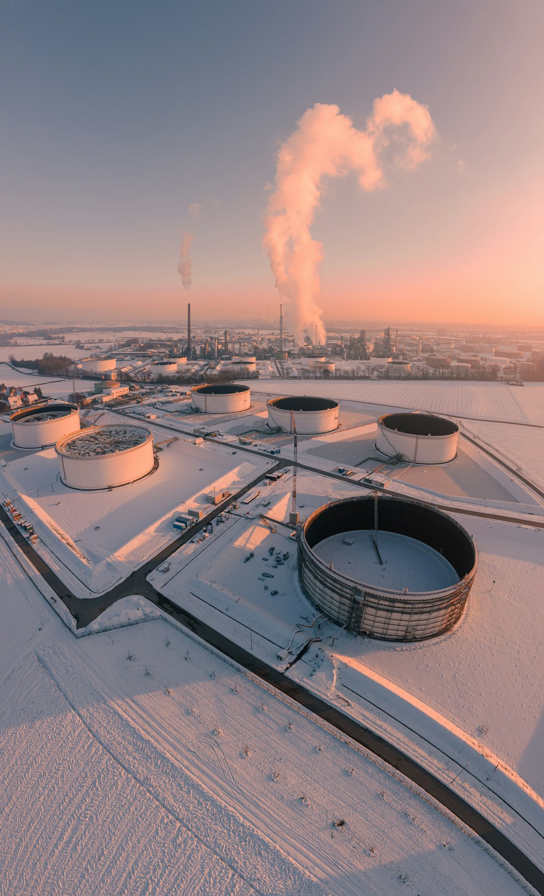 industrial-tanks-in-a-snowy-landscape-at-sunrise-qvcvkdihxzu